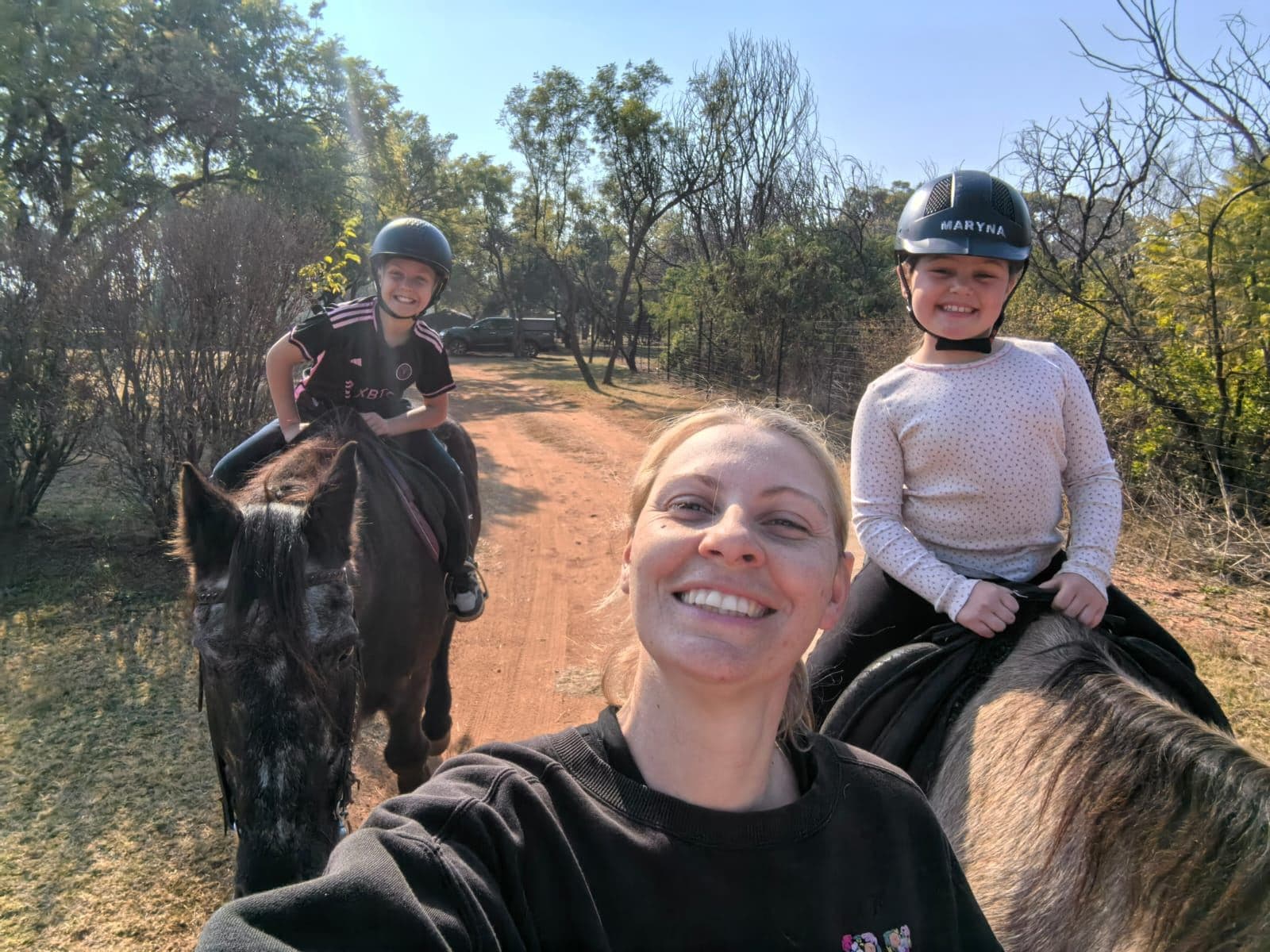 Instructor taking a selfie with two smiling young riders on their ponies
