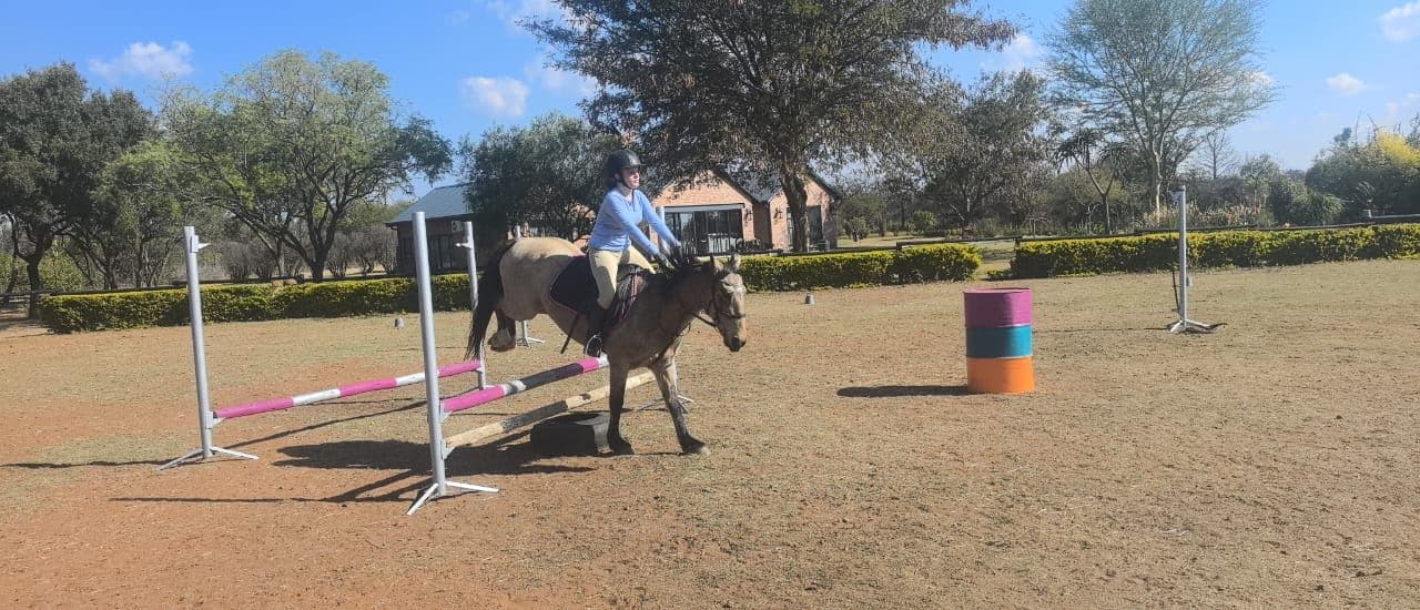 Rider approaching a jump in the arena